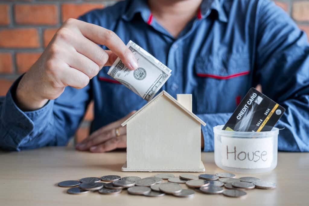 Man putting coins into money box with savings and analysis busin